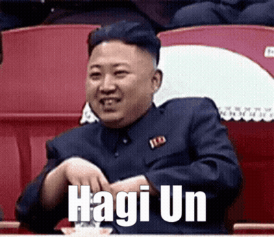 Man In Suit Sitting In Stadium With Hagi Un On Face GIF
