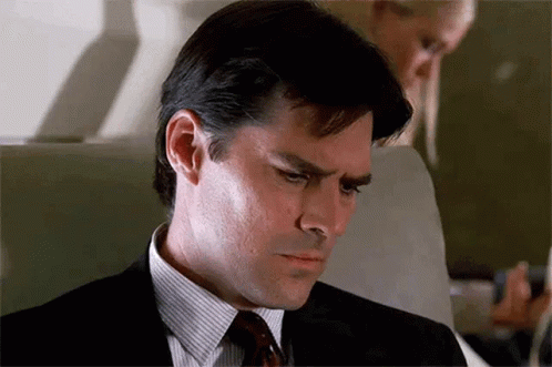 Man In Suit Sitting On Airplane Looking Down GIF