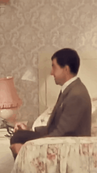 Man In Suit Sitting On Bed GIF