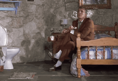 Man In Suit Sitting On Bed In Bathroom GIF