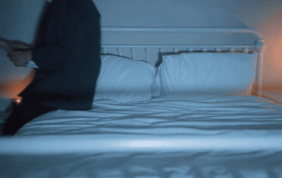 Man In Suit Sitting On Bed GIF