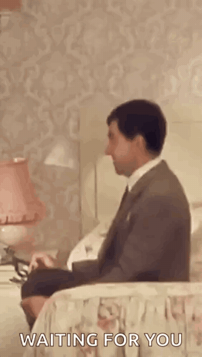 Man In Suit Sitting On Bed Waiting GIF