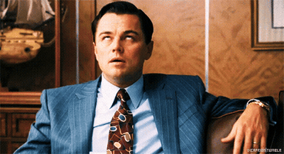 Man In Suit Sitting On Couch Hands On Hips GIF