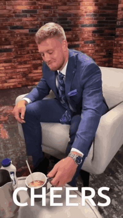 Man In Suit Sitting On Couch With Cereal Saying Cheers GIF