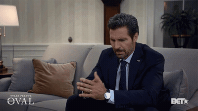 Man In Suit Sitting On Couch With Oval GIF