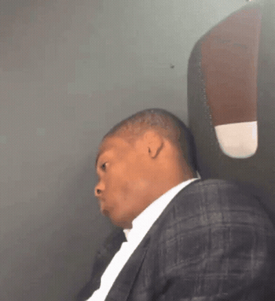Man In Suit Sitting On Plane GIF