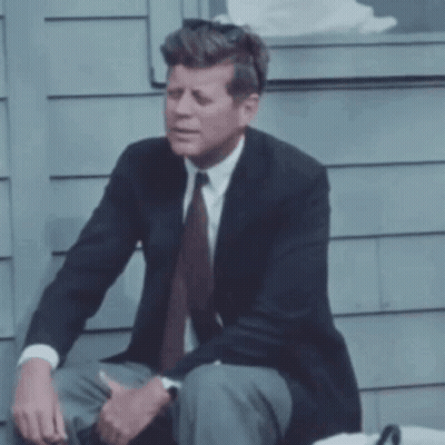 Man In Suit Sitting On Sidewalk GIF