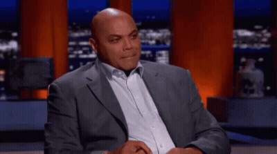 Man in Suit Sitting on Stage With Hands Folded