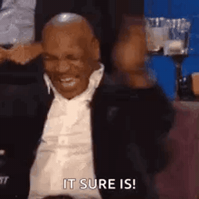 Man In Suit Sitting Smiling Hand To Head GIF