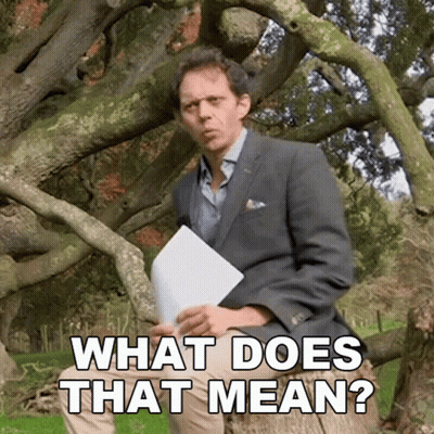 Man In Suit Sitting Under Tree Holding Paper Saying What Does That Mean GIF