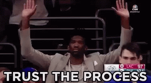 Man In Suit Sitting With Arms Up Trust The Process GIF