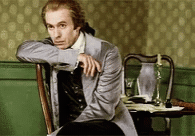 Man In Suit Sitting With Hand On Shoulder GIF