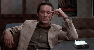 Man In Suit Sitting With Hands On Head GIF