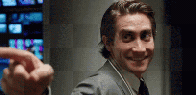 Man In Suit Smiling And Pointing At Camera With Headphones GIF
