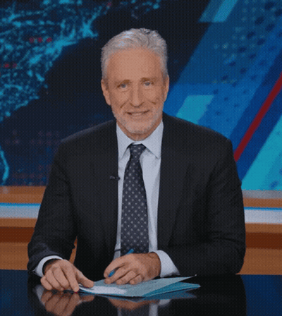 Man In Suit Smiling At Desk GIF