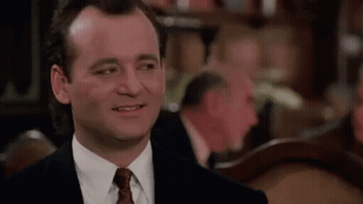 Man In Suit Smiling At Table GIF