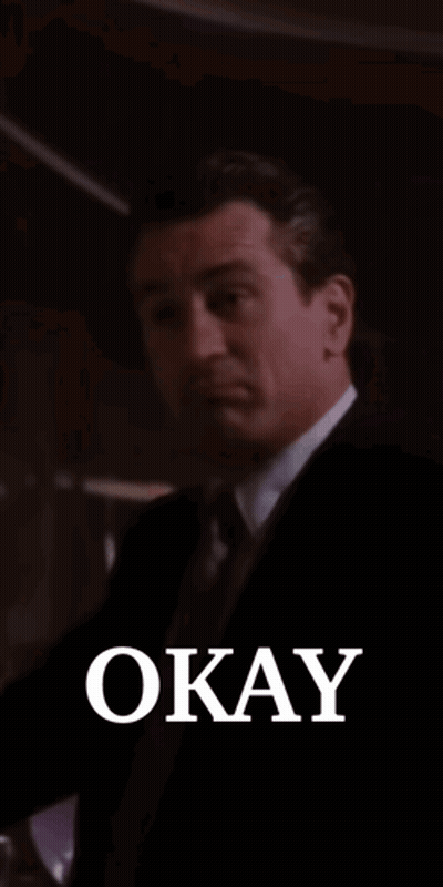 Man In Suit Smiling Holding Glass Saying Okay GIF