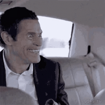 Man In Suit Smiling In Back Seat GIF