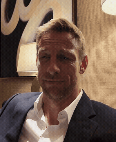 Man In Suit Smiling In Front Of Painting GIF