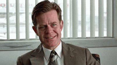 Man In Suit Smiling In Front Of Window Saying Queen GIF