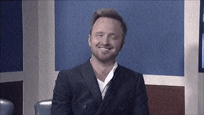 Man In Suit Smiling Sitting In Room GIF