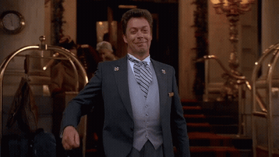 Man In Suit Smiling With Lapel Pin GIF