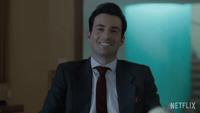 Man In Suit Smiling With Netflix Logo GIF