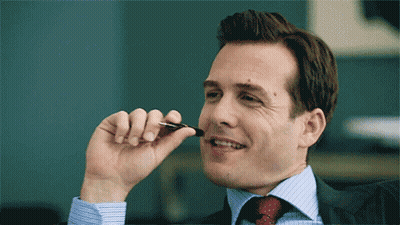 Man In Suit Smiling With Pen In Mouth GIF