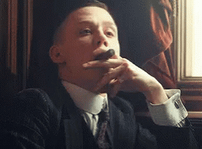 Man In Suit Smoking Cigar By Window GIF