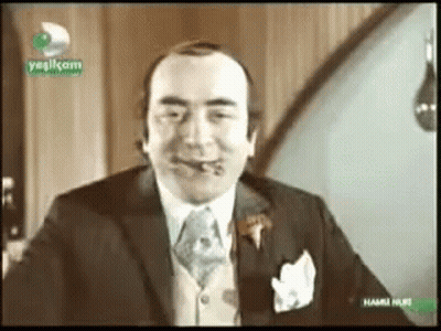 Man In Suit Smoking Cigar On TV Saying Yesilkom GIF