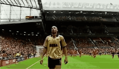 Man In Suit Speaking Into Microphone At Champions League Logo GIF