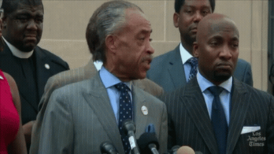 Man In Suit Speaking Into Microphone Los Angeles Times GIF