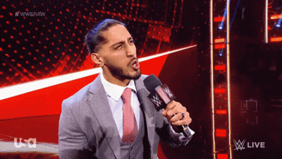 Man In Suit Speaking Into Microphone On TV Show GIF