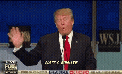 Man In Suit Speaking Into Microphone Saying Wait A Minute GIF