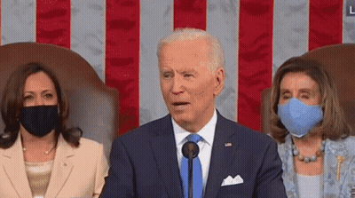 Man In Suit Speaking Into Microphone With Two Masked Women GIF