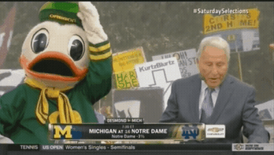 Man In Suit Standing Before Duck Mascot GIF