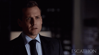Man In Suit Standing Before Escathon Sign GIF