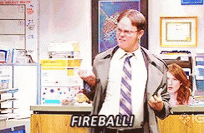 Man In Suit Standing Before Fireball Sign GIF