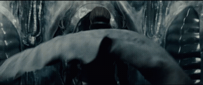 Man In Suit Standing Before Large Object GIF