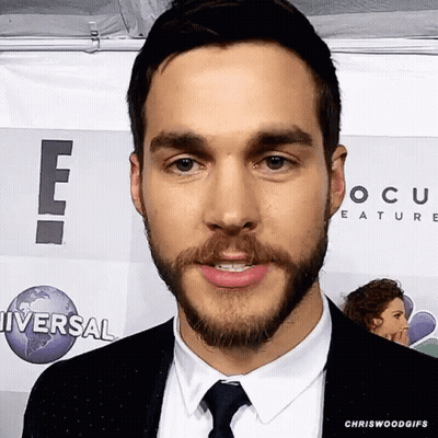 Man In Suit Standing Before Universal Sign GIF