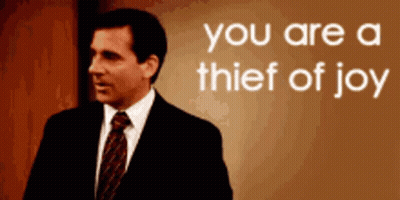 Man In Suit Standing Before You Are A Thief Of Joy Sign GIF