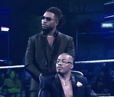 Man In Suit Standing Beside Seated Man Tiffanyluv24 GIF