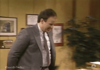 Man In Suit Standing By Saved By The Bell Sign GIF