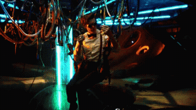 Man In Suit Standing In Dark Room With Light On Face GIF