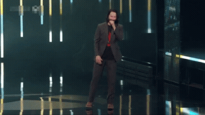 Man In Suit Standing In Front Of Breathtaking Screen GIF