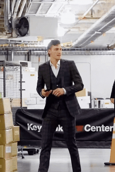 Man In Suit Standing In Front Of Center Sign GIF
