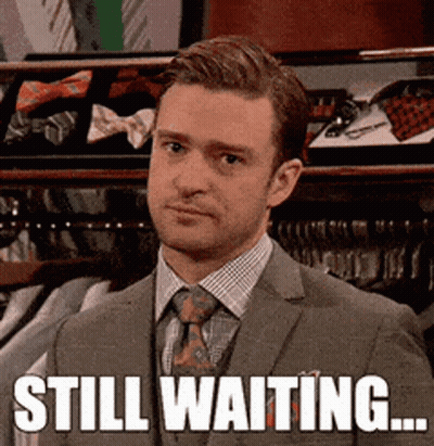 Man In Suit Standing In Front Of Closet Saying Still Waiting GIF