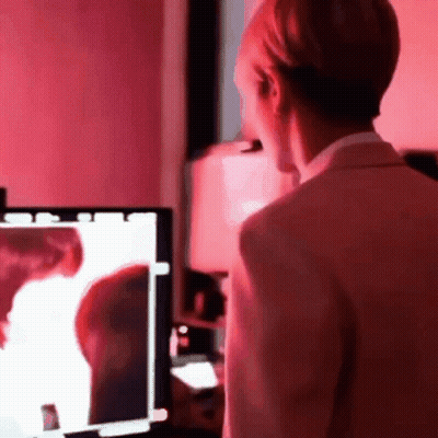 Man In Suit Standing In Front Of Computer Monitor With Red Light GIF