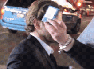 Man In Suit Standing In Front Of Hollywood Awards Screen GIF