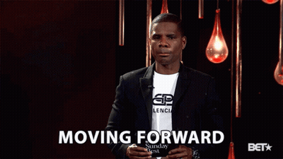 Man In Suit Standing In Front Of Moving Forward Sign GIF